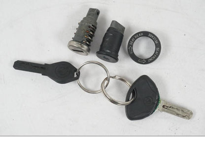 Baksidan på <p>Låssats från BMW R 1200 GS 2006.</p>

<p>1st nyckel, plastnyckel, tändningslås, sadellås och tanklock.</p>

<p>Repor finns på tanklocket se bild.</p> motorcykel.