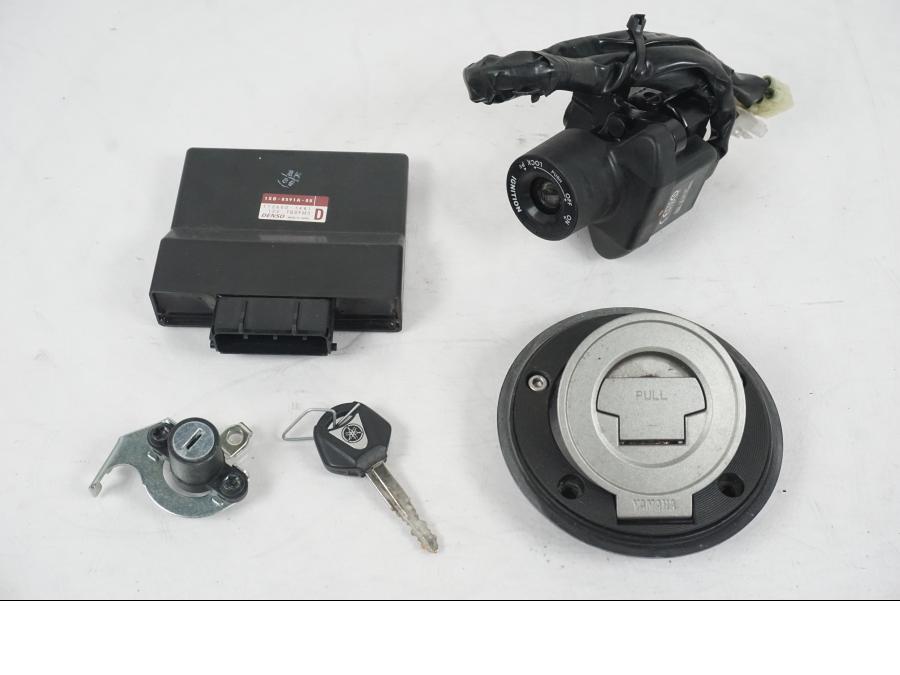 Framsidan på <p>Låssats från Yamaha MT-07 2014.</p>

<p>1st nyckel (svart), tändningslås, antenn, sadellås, CDI och tanklock.</p> motorcykel.