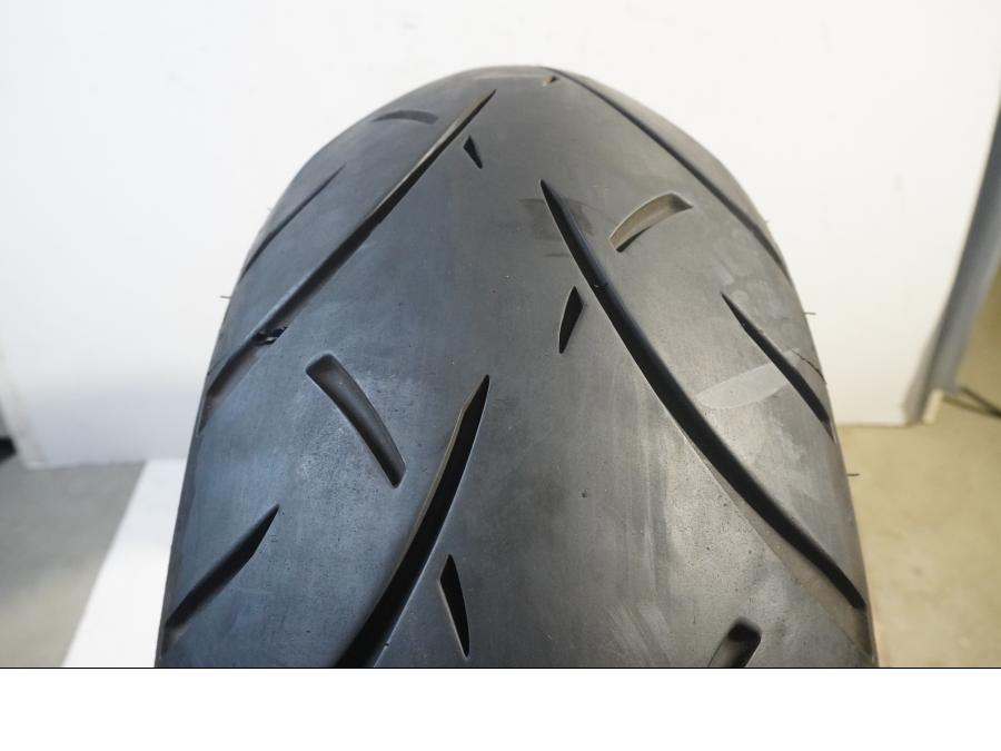 Baksidan på <p>Bikepart-däck, modell utan specifik årsmodell och med okänt skick, erbjuder standardegenskaper för cyklar. Däckets exakta prestanda och användningshistorik är inte specificerade, vilket innebär att eventuella defekter eller slitage ej har bedömts.</p> motorcykel.