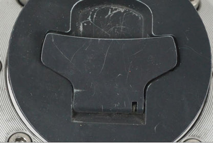 Vänster sida på <p>Tanklock från Suzuki GSX 750 W 2002.</p>

<p>Med 1st nyckel. Repor finns på tanklocket se bilder.</p> motorcykel.