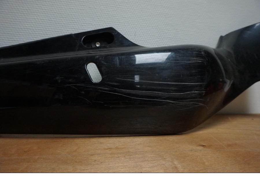 Baksidan på <p>Bakvinge höger från Suzuki GSX-R 750 1992.</p>

<p>Grova repor.</p> motorcykel.