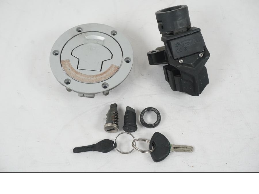 Framsidan på <p>Låssats från BMW R 1200 GS 2006.</p>

<p>1st nyckel, plastnyckel, tändningslås, sadellås och tanklock.</p>

<p>Repor finns på tanklocket se bild.</p> motorcykel.