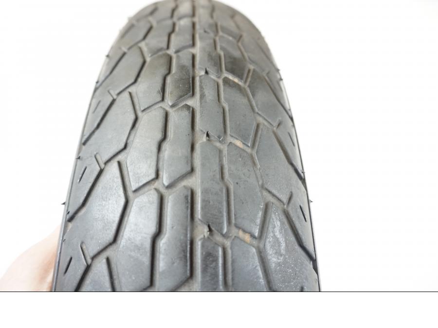 Höger sida på <p>Framdäck Bridgestone Exedra L309 110/90-19</p>

<p>40% mönsterdjup kvar. Tillverkningsår hittas ej, slitage normalt.</p> moped.