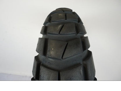 Snett nerifrån på <p>Begagnad däck av märket Metzeler.</p>

<p>Modell Karoo 3.</p>

<p>Dimension 120/70 R 19 M/C 60T M S. </p>

<p>Mönsterdjup ca: 40% kvar.</p>

<p>Tillv: Vecka 4, år 2019.</p> moped.