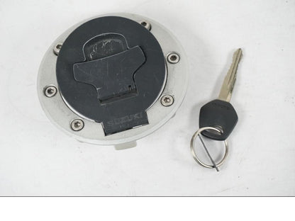 Framsidan på <p>Tanklock från Suzuki GSX 750 W 2002.</p>

<p>Med 1st nyckel. Repor finns på tanklocket se bilder.</p> motorcykel.
