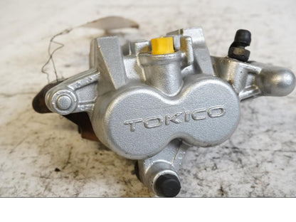 Framsidan på <p>Bromsok höger fram från Kawasaki VN 1700 Classic Tourer 2009.</p>

<p>Tokico, 2-kolv.</p> motorcykel.