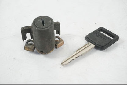 Baksidan på <p>Låssats från Suzuki TL 1000 S 1997.</p>

<p>Tändningslås, tanklock, sadellås och 1st nyckel.</p>

<p>Repor finns på tanklocket, slitage av lack på tändningslåset även att gummi skyddet för kabel har ett hål se bild.</p> motorcykel.