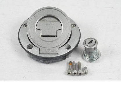 Baksidan på <p>Låssats från Yamaha XT 1200 Z ABS 2011.</p>

<p>Cdi, tändningslås, antenn, tanklock, sadellås, toppboxlås och 3st nycklar. Finns en skada på sadellåsmekanismens skyddsgummi se bild.</p> motorcykel.