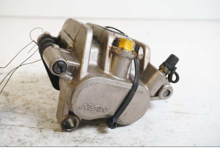 Framsidan på <p>Bromsok höger fram från Honda VFR 750 F 1988.</p>

<p>Nissin, 2-kolv, saknar gummit vid glidfästet.</p>

<p>Okej skick.</p> motorcykel.