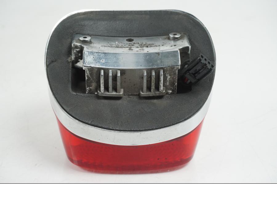 Snett uppifrån på <p>Baklampa från HD Sportster XL 1200 Custom 1999. </p>

<p>Med fästplatta 68066-99. OBS skruvar som håller glaset saknas. Förövrigt bra skick.</p> motorcykel.