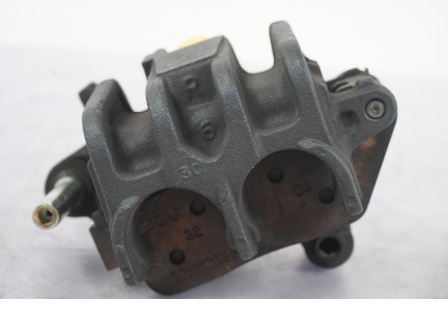 Snett nerifrån på <p>Bromsok höger fram från Honda CB 600 Homet - 03, Nissin 2-kolv.</p>

<p>Repa finns se bild.</p> motorcykel.