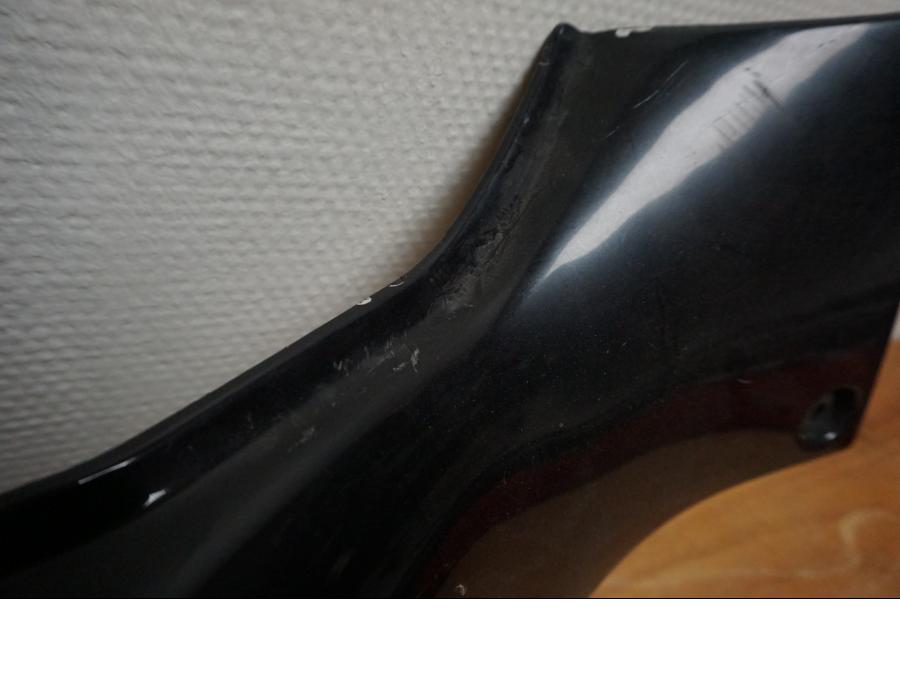 Snett uppifrån på <p>Bakvinge höger från Suzuki GSX-R 750 1992.</p>

<p>Grova repor.</p> motorcykel.