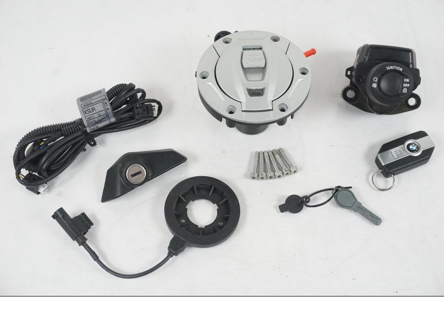 Framsidan på <p>Låssats från BMW R 1200 RS 2015.</p>

<p>Keyless Ride, tändningslås, en grå plastnyckel, tanklock, antenn, kablage, fjärrnyckel och sadellås.</p> motorcykel.