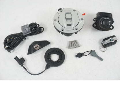 Framsidan på <p>Låssats från BMW R 1200 RS 2015.</p>

<p>Keyless Ride, tändningslås, en grå plastnyckel, tanklock, antenn, kablage, fjärrnyckel och sadellås.</p> motorcykel.