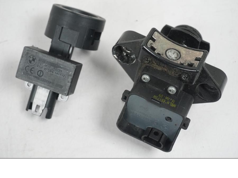 Baksidan på <p>Låssats från BMW F 800 R 2010.</p>

<p>Tändningslås med antenn lite ful i ena fästet, tanklock, sadellås och 1st nyckel.</p> motorcykel.