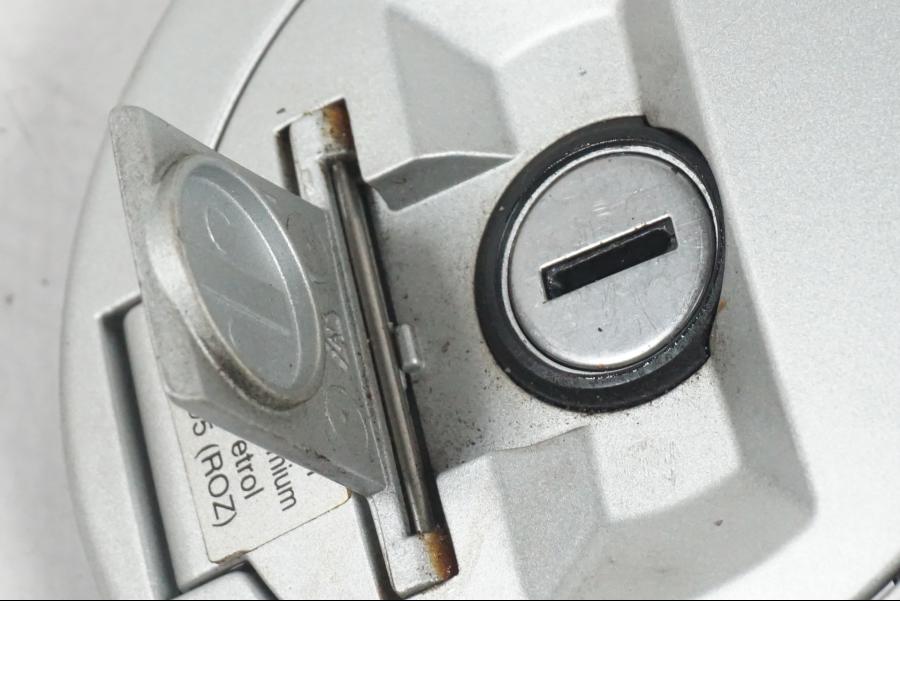 Snett nerifrån på <p>Låssats från BMW F 800 R 2011.</p>

<p>Tändningslås, antenn, tanklock med repor, sadellås och 1st nyckel. Ytliga repor finns på tanklocket.</p> motorcykel.