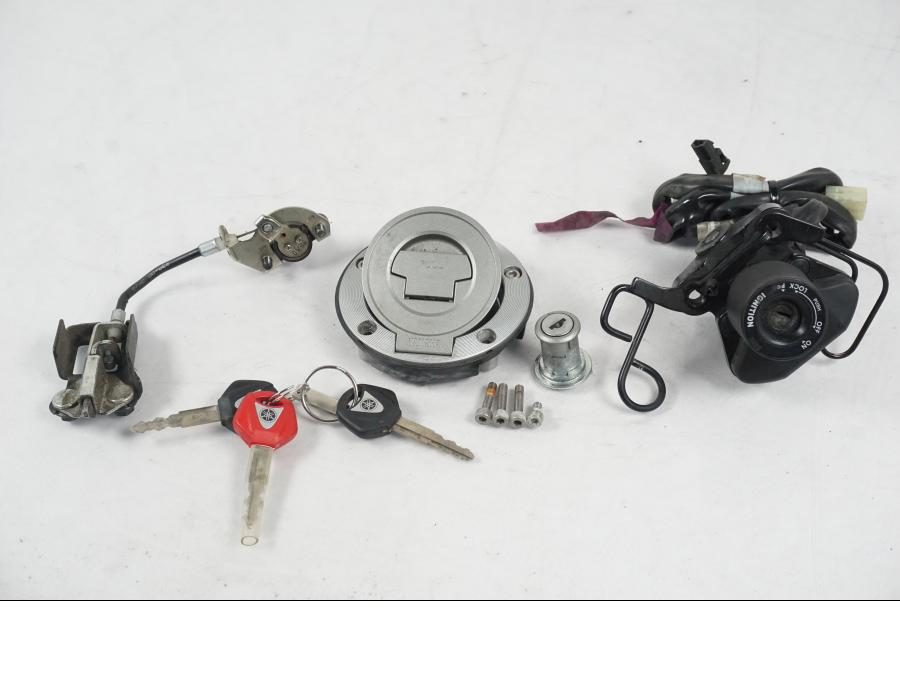 Framsidan på <p>Låssats från Yamaha XT 1200 Z ABS 2011.</p>

<p>Cdi, tändningslås, antenn, tanklock, sadellås, toppboxlås och 3st nycklar. Finns en skada på sadellåsmekanismens skyddsgummi se bild.</p> motorcykel.