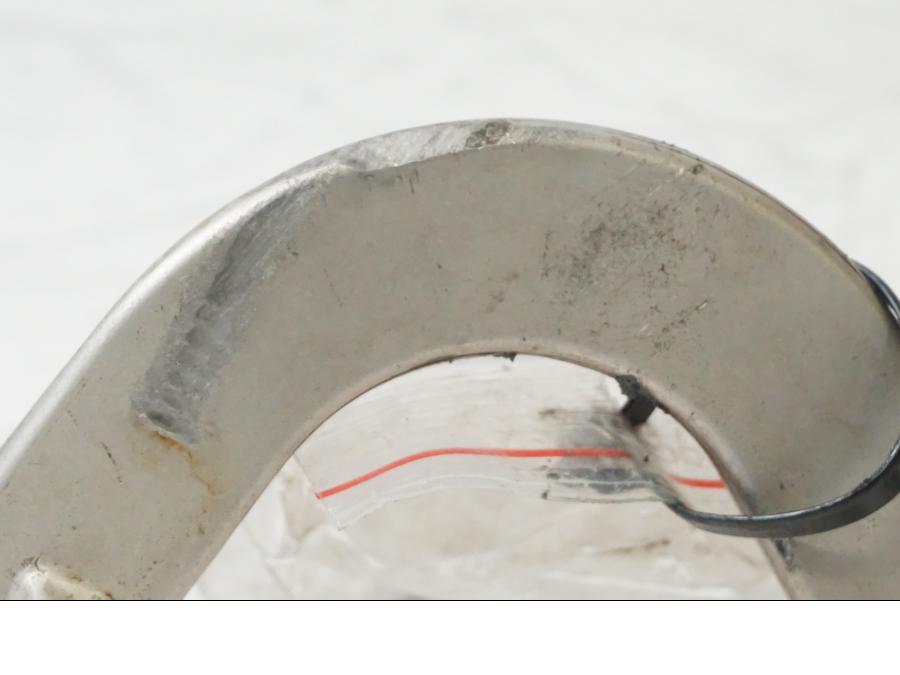 Snett nerifrån på <p>Bromspedal från Husqvarna TE 310 2009.</p>

<p>Skavmärke finns se bild.</p> motorcykel.