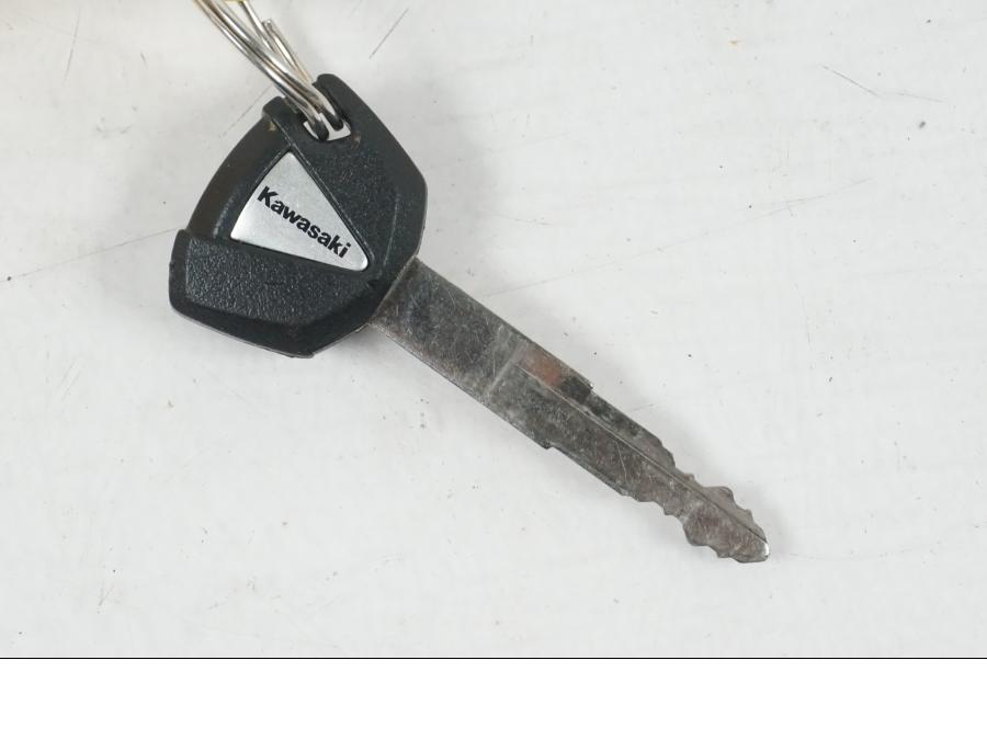 Snett uppifrån på <p>Låssats från Kawasaki ER-6N ABS 2014.</p>

<p>1st nyckel, tändningslås, sadellås, tanklock.</p>

<p>(småmärken finns på locket).</p> motorcykel.