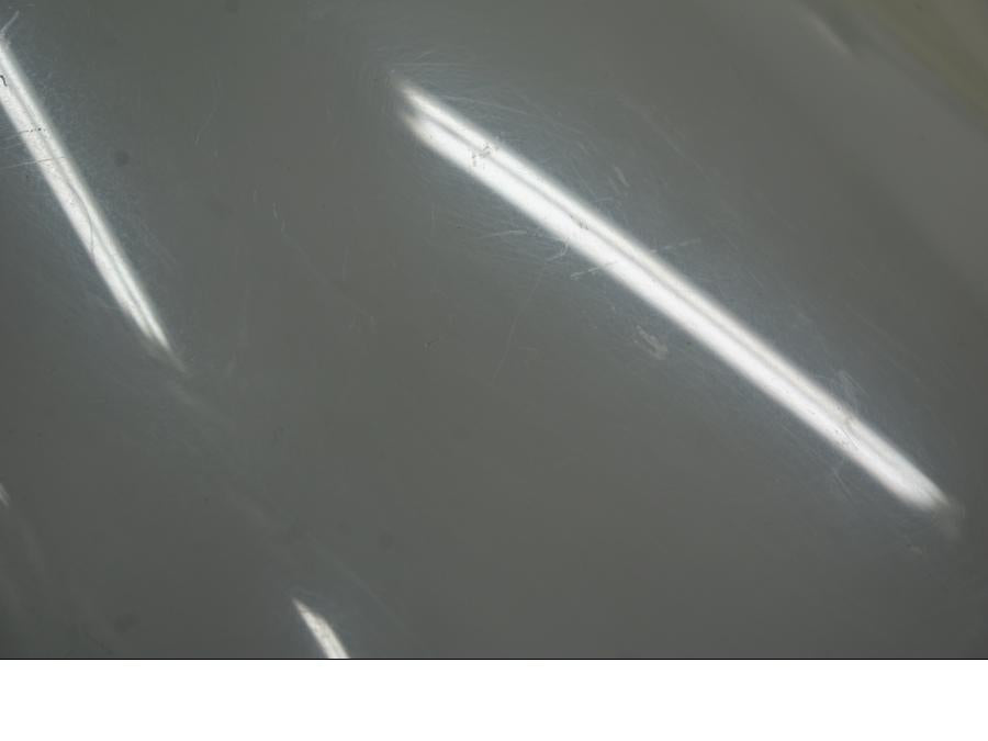 Snett uppifrån på <p>Vindruta till Aprilia RSV 1000 2002.</p>

<p>Vindrutan är solblekt och har en gul "toning" sen vanlig transparant färg beroende på från vilken vinkel man kollar på den.</p>

<p>Ytliga repor / repor finns se bilder.</p> motorcykel.