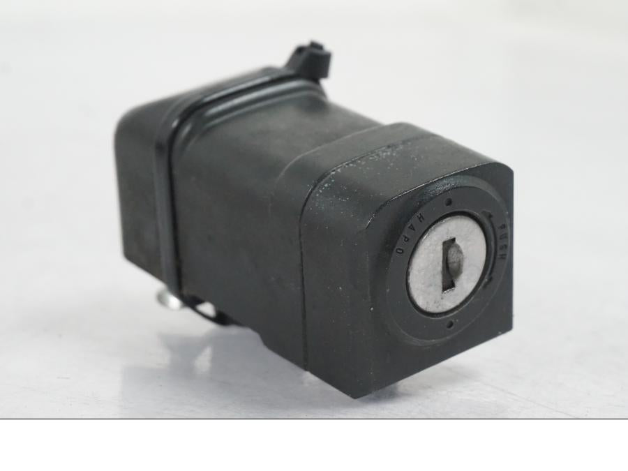 Baksidan på <p>Låssats från Honda VT 750 C2 2008.</p>

<p>Tändningslås, antenn, styrlås, tanklock, hjälmlås, 2st nycklar och CDI.</p> motorcykel.