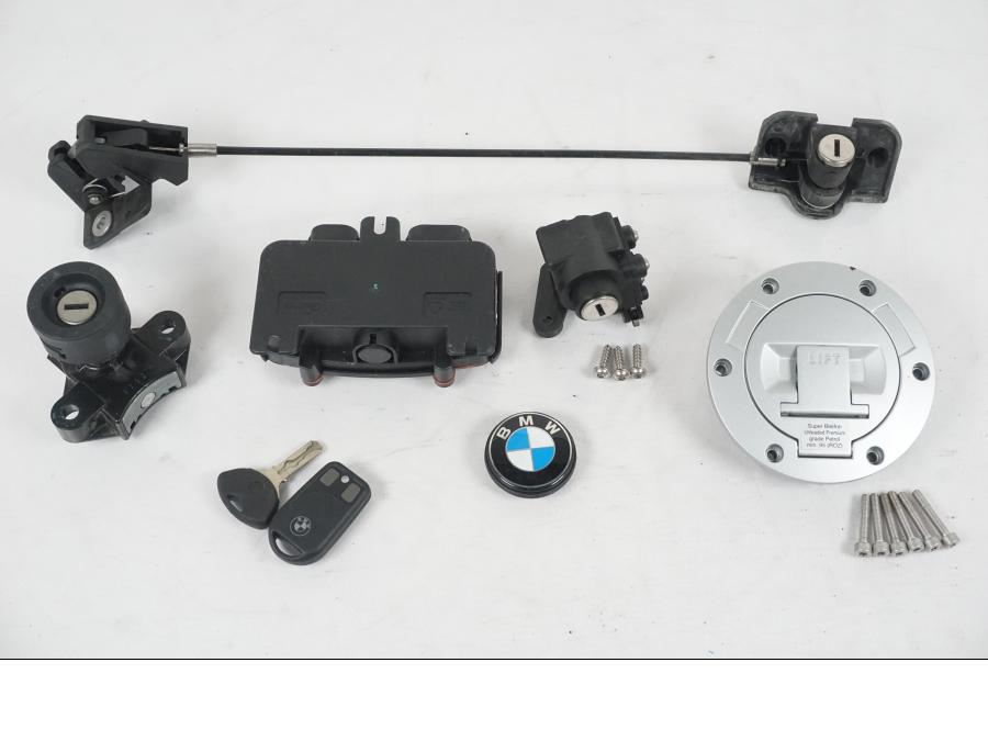 Framsidan på <p>Låssats från BMW R 1200 RT 2013.</p>

<p>Tändningslås (endast mekanismen), tanklock, sadellås, larmdosa, 1st nyckel och 1st dosa.</p> motorcykel.