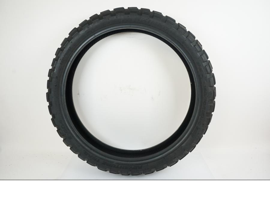 Framsidan på <p>Däck: Shinko Adventure Trail E-804.</p>

<p>Dimension: 120/70-R19 M/C 60 H.</p>

<p>Tillv. 0118</p>

<p>Mönsterdjup: ca. 40 %.</p> motorcykel.