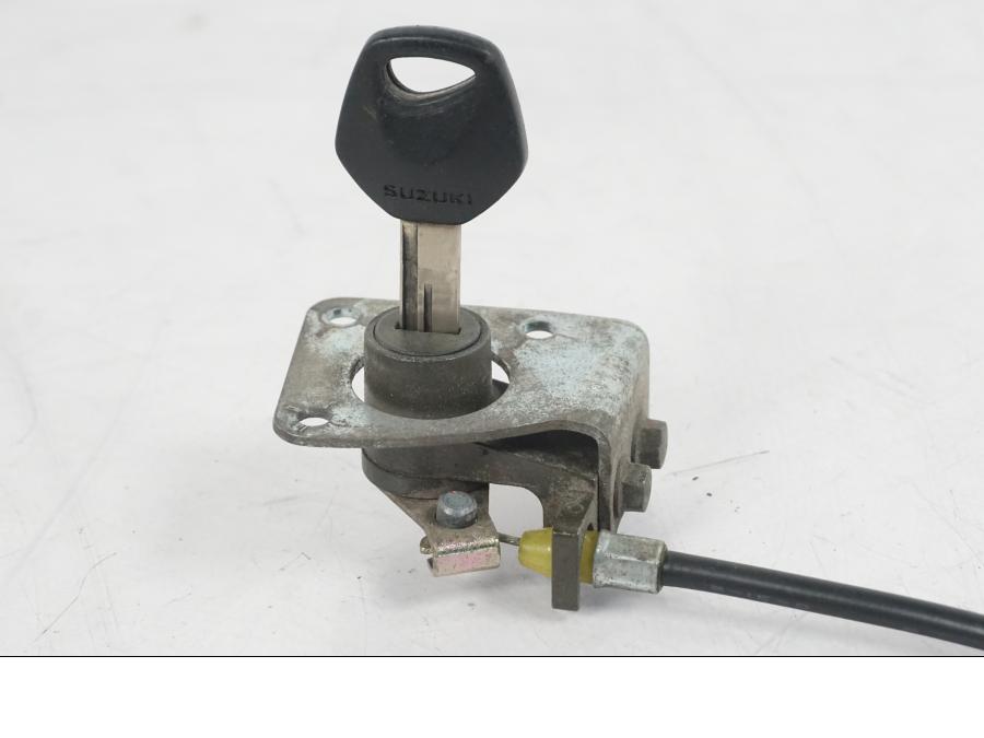 Snett uppifrån på <p>Sadellås från Suzuki GSX 750 W 2002.</p>

<p>Med 1st nyckel.</p> motorcykel.