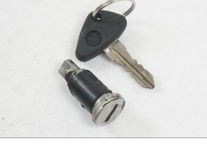 Baksidan på <p>Låssats från BMW K 1200 RS 1998.</p>

<p>Tändningslås, 1st nyckel, tanklock och sadellås.</p> motorcykel.