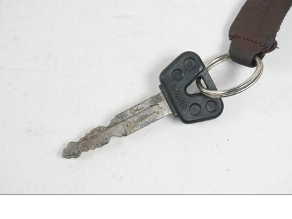 Baksidan på <p>Tanklock från Yamaha FZ-S 600 1998.</p>

<p>Med 1st nyckel och sadellås.</p> motorcykel.