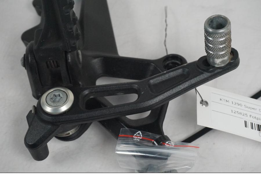 Vänster sida på Fotpinnefäste från en KTM 1290 Super Duke GT -2017 motorcykel.